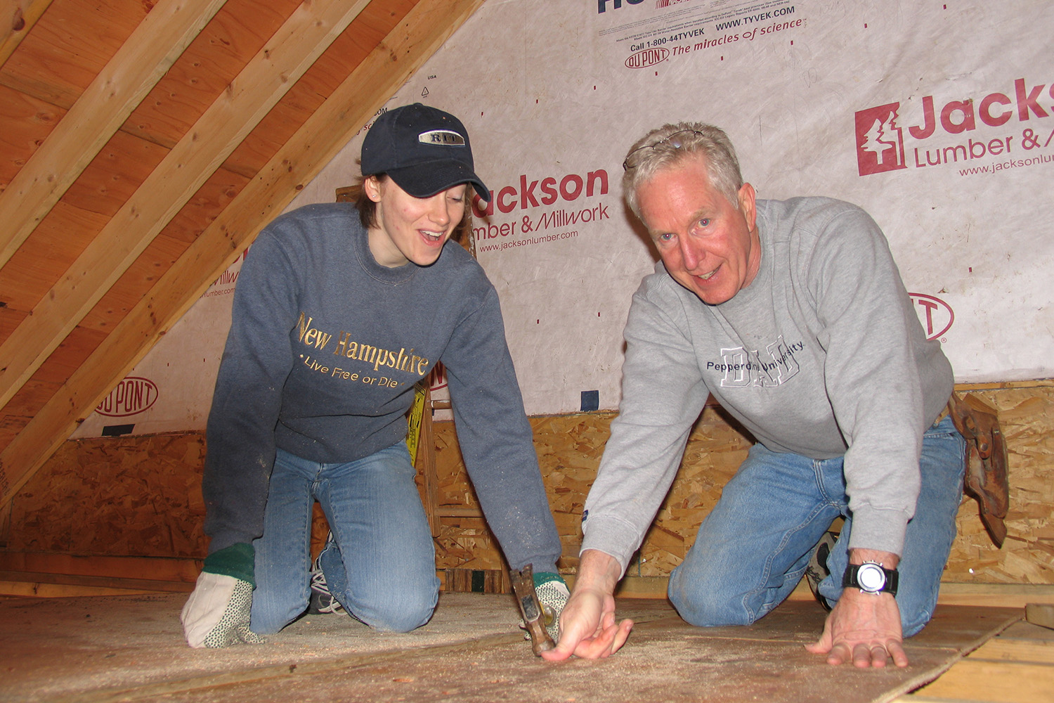 John Tocci and a Tocci employee hammer away at the wooden floor 