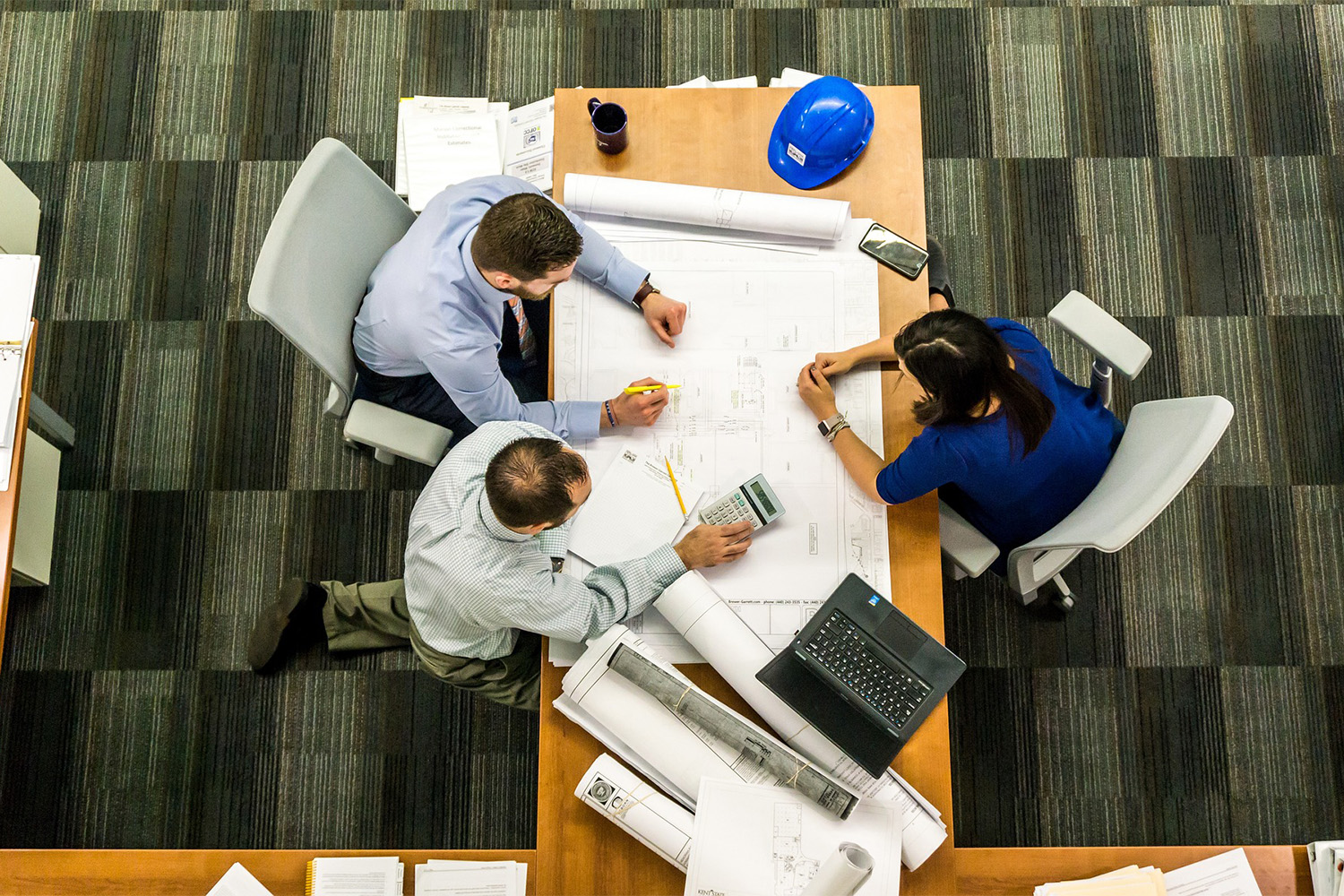 Birds-eye-view of students sitting at table, collaborating on a workshop 