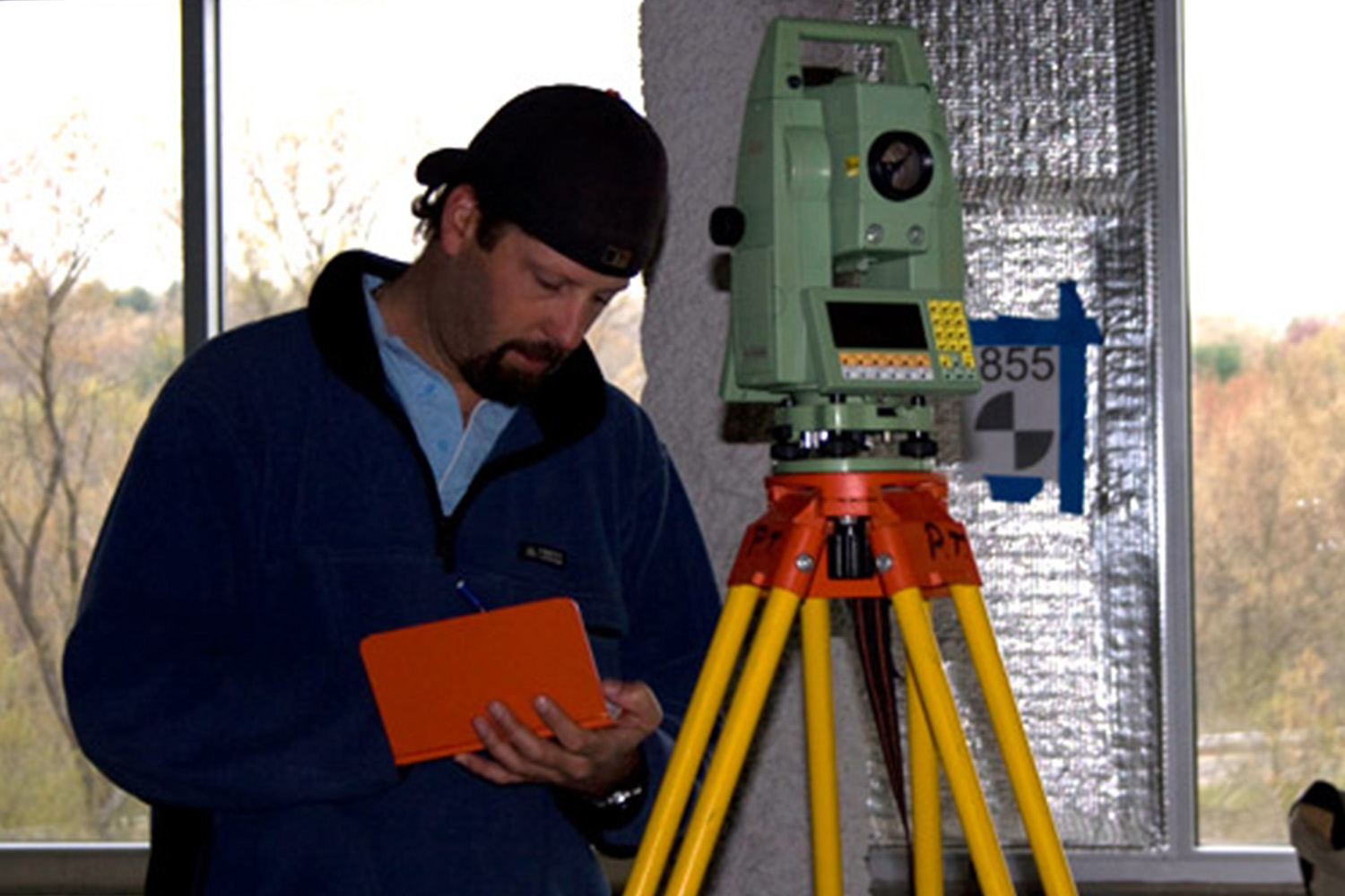 A man takes notes in front of a laser scanner at Autodesk