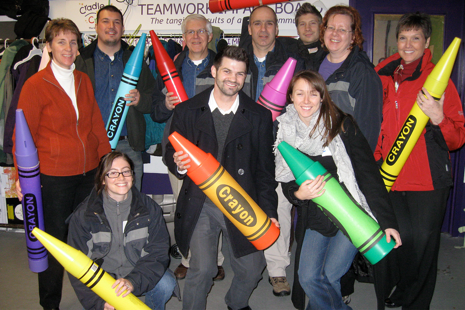Tocci volunteers holding big crayons for photo 
