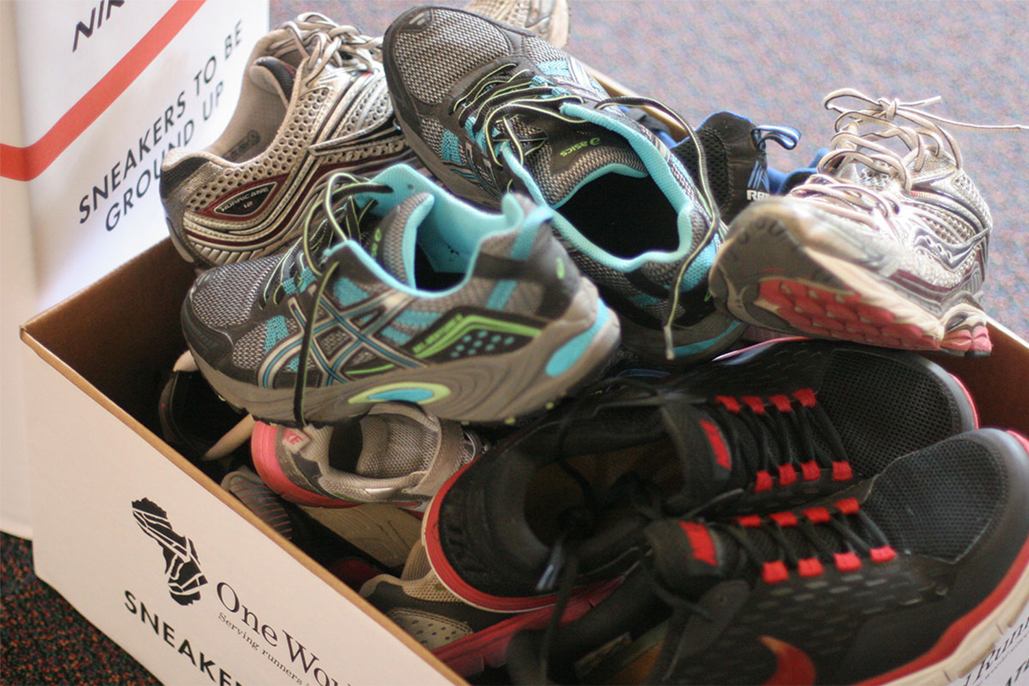two white cardboard boxes filled with donated shoes
