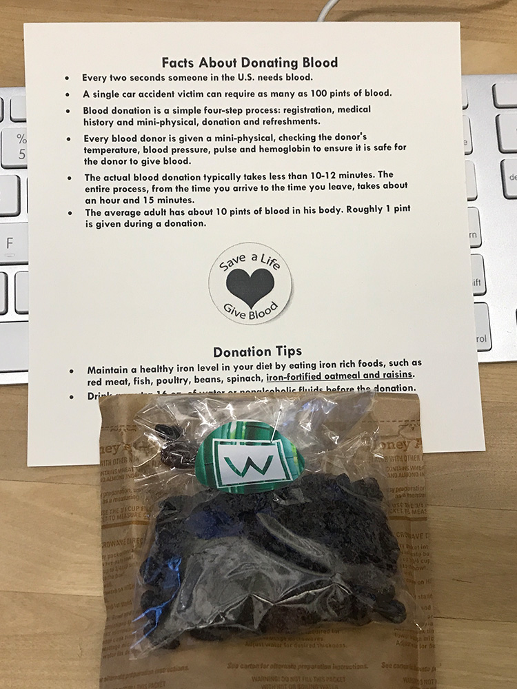 A dark chocolate desk drop with facts about heart health placed on a staff member's keyboard