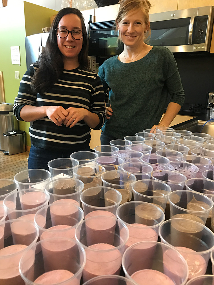 Jessica Ronayne and Caitlin Fitzgerald in the kitchen with smoothie samples of various flavors