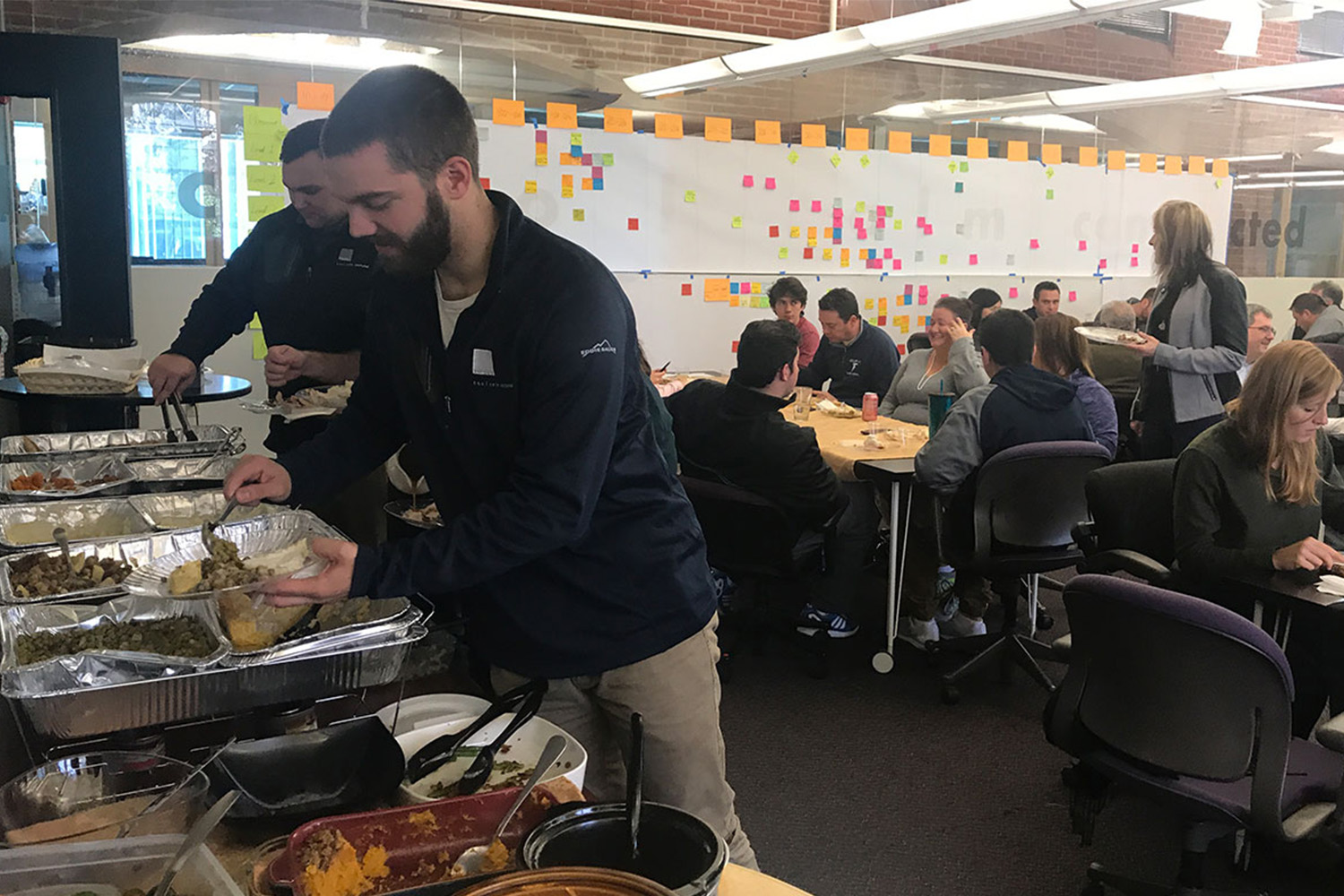 Dan Arenz fixes his meal at a buffet table during a Thanksgiving potluck