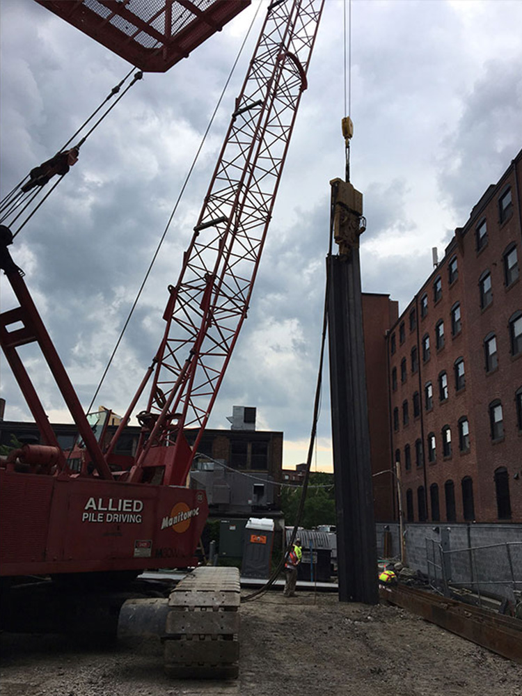 Hydraulic crane in front of redbrick building