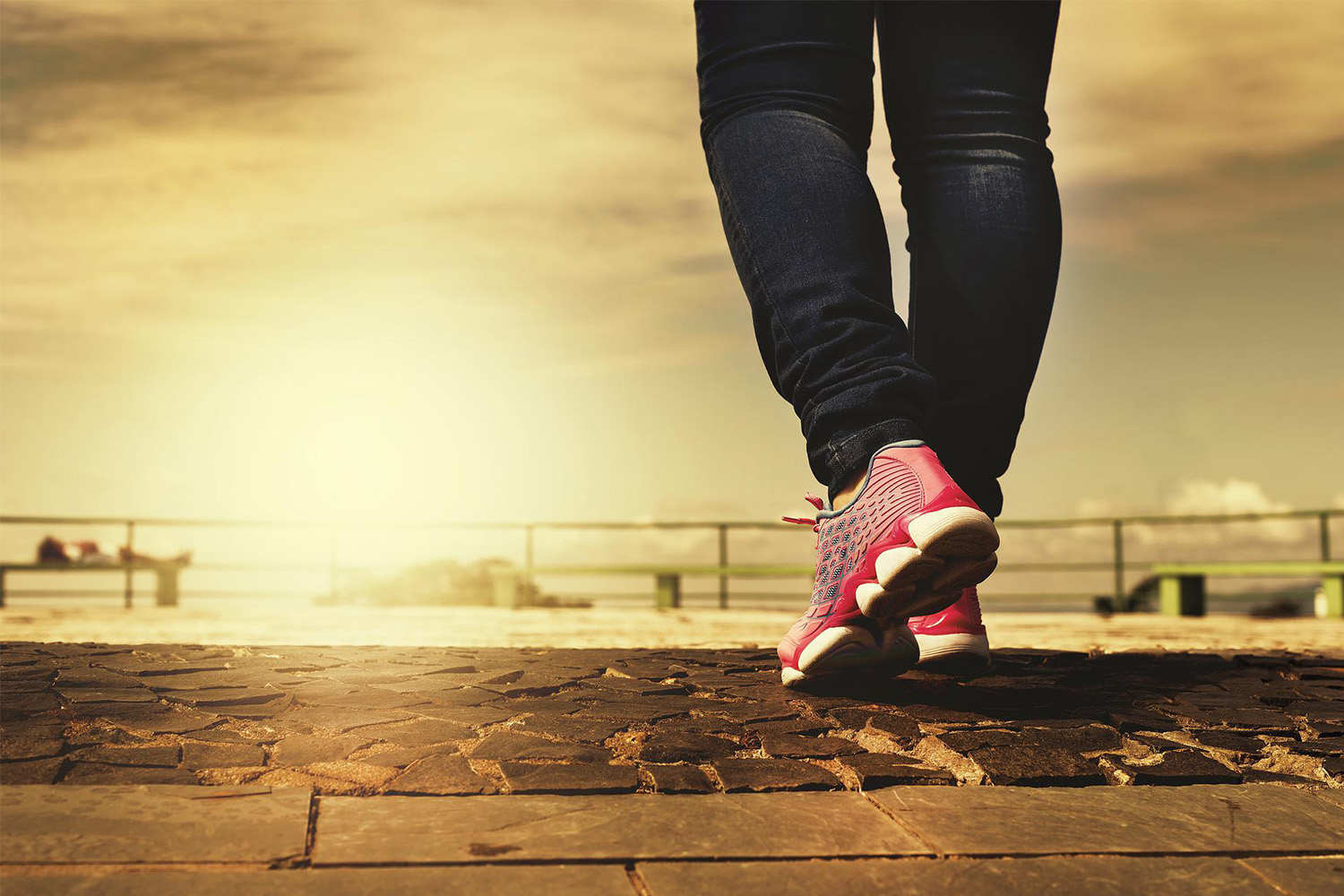 Woman wearing jeans and sneakers during sunset