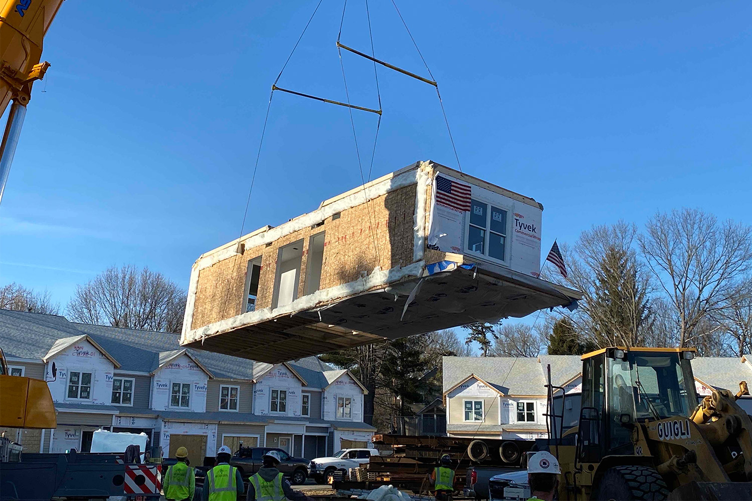 Crane lifting a modular box at topping off of Natick project site