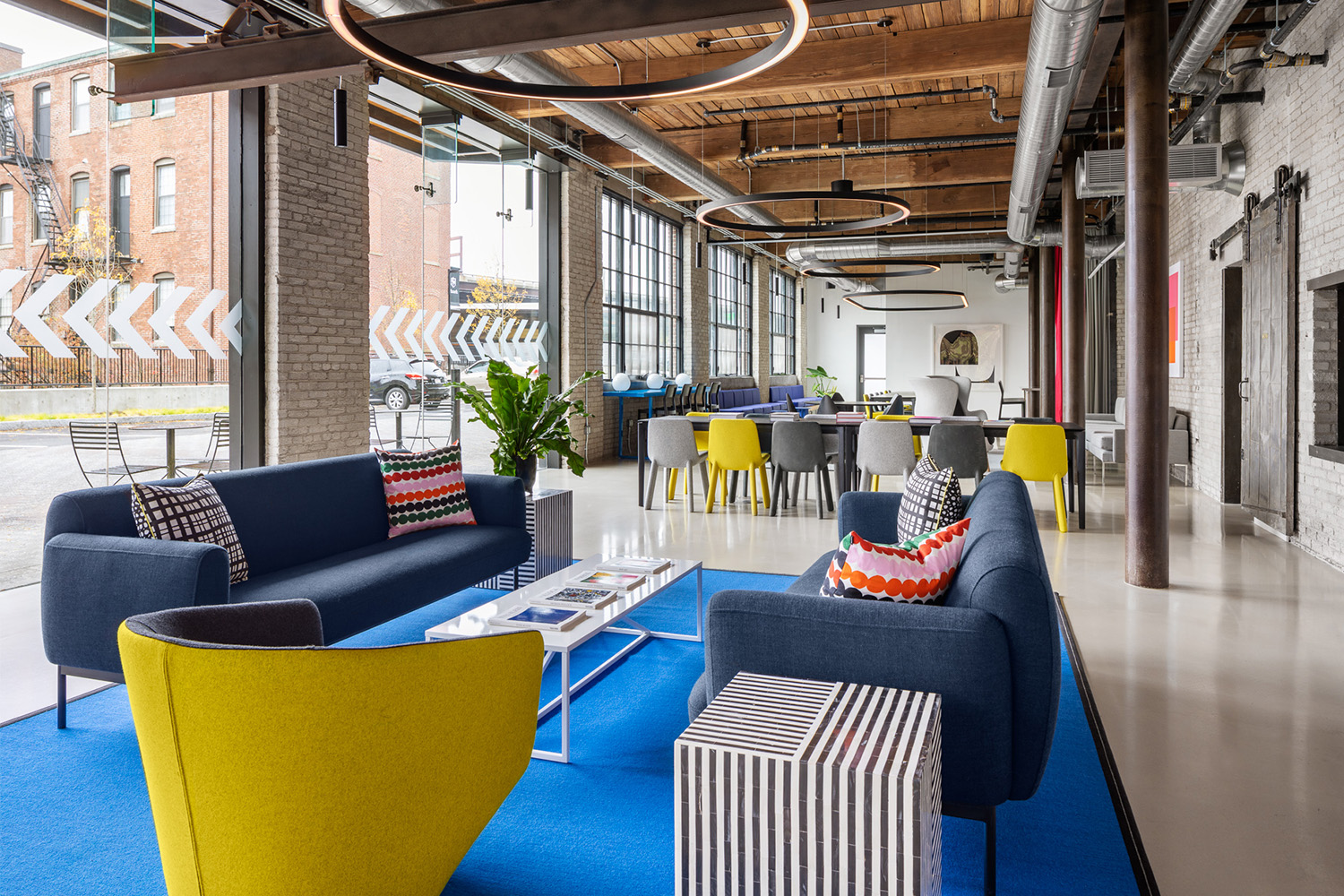 Long view of couches in lobby area, beside windows which take up most wall space 