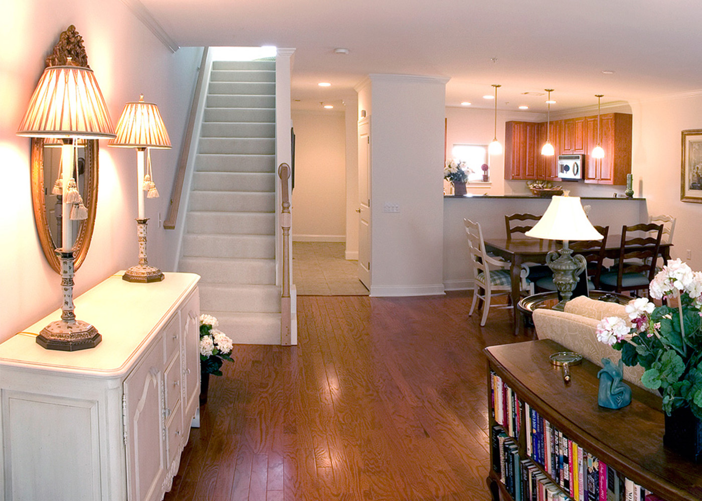 Living area with white couch and library as seen from front door entryway 