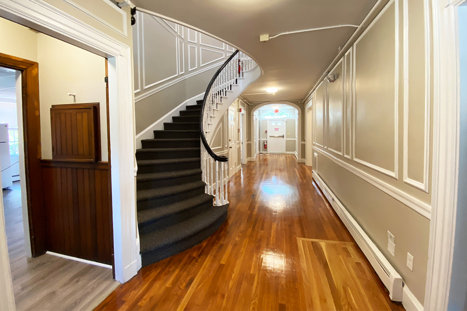 Main entryway for Cedar House A, with wooden hallway and staircase to left