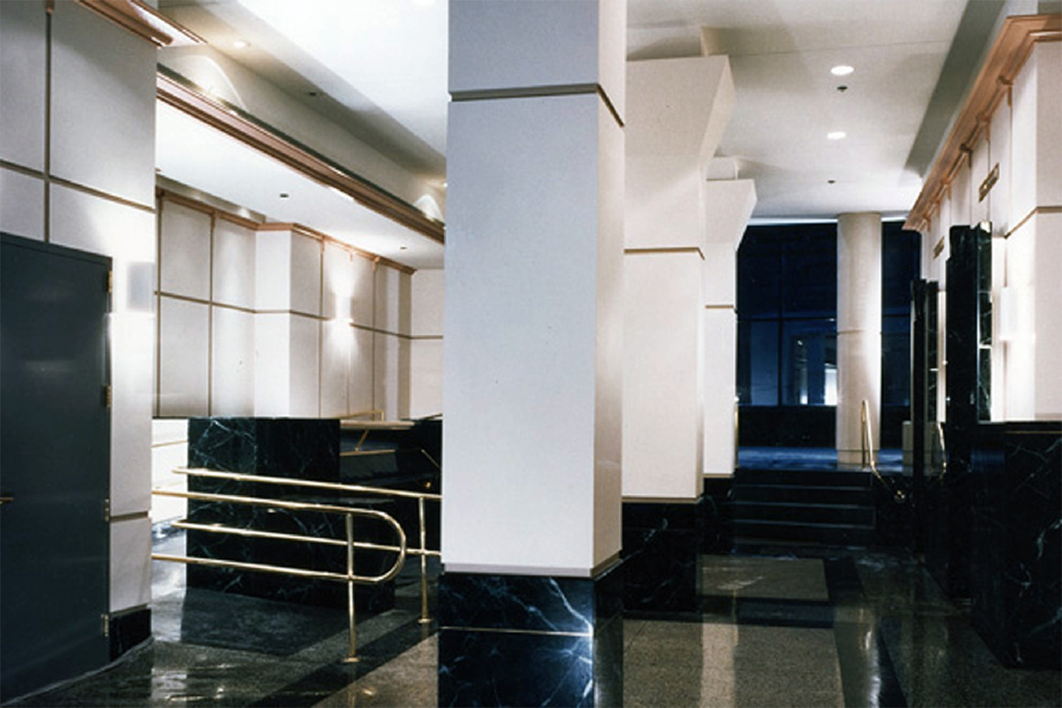 Reception area with white pillars and walls, and black marble flooring