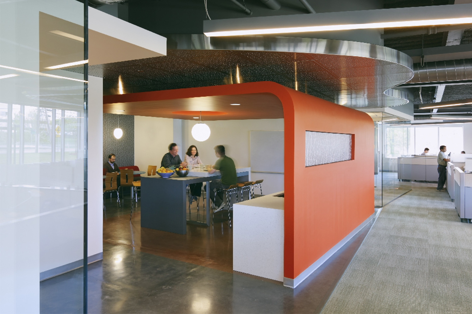 Café area under red-orange roof structure, outside of cubicle offices 