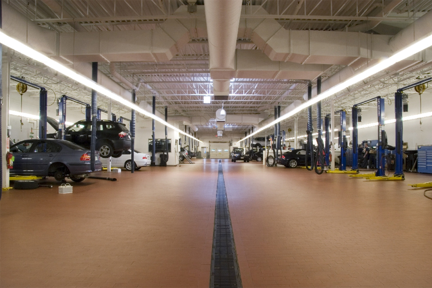 Longview of BMW service station, with various cars to the left and right being repaired 