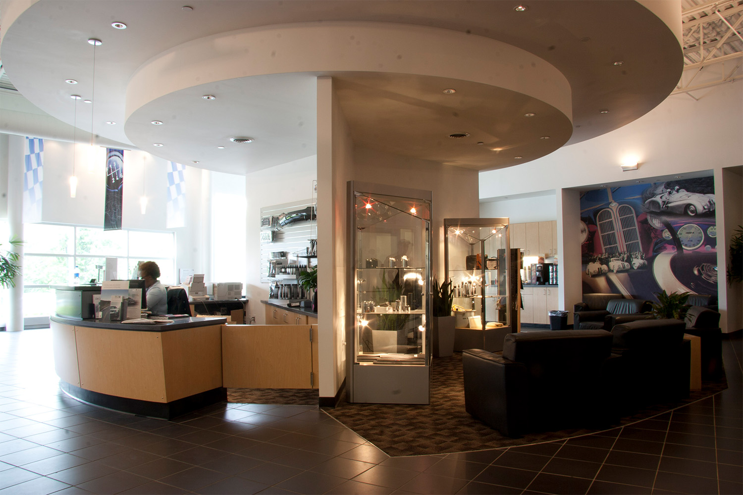 Circular reception desk next to lounge area with black leather couch 