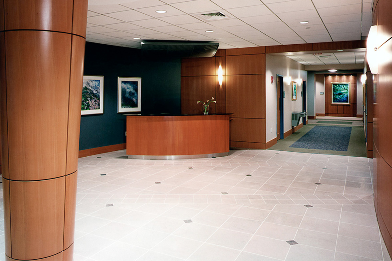 Spacious hallway with sconce lighting fixtures and wooden walls 