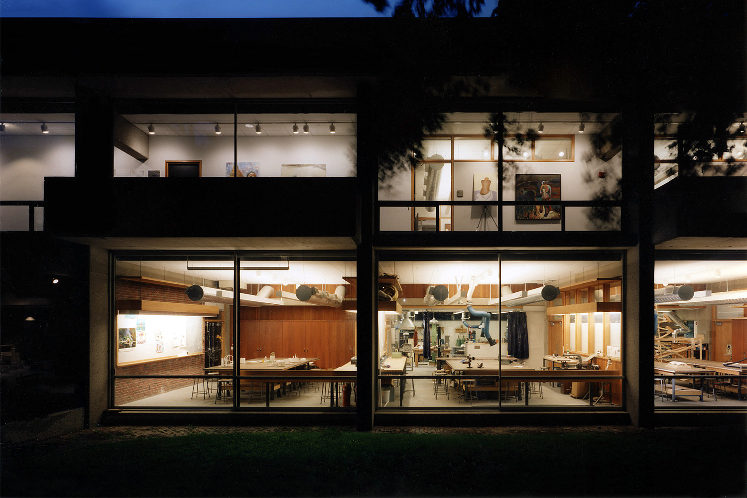 Nighttime exterior of Elson Arts Center, with visibility of building's interior through large windows 