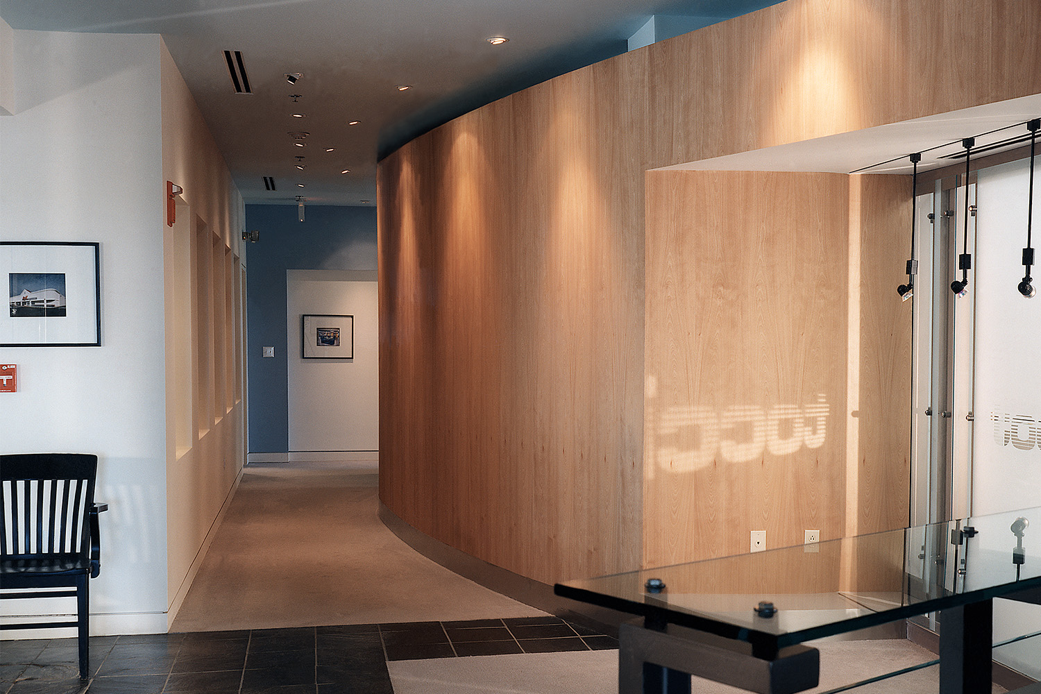 Hallway next to office area with wooden wall
