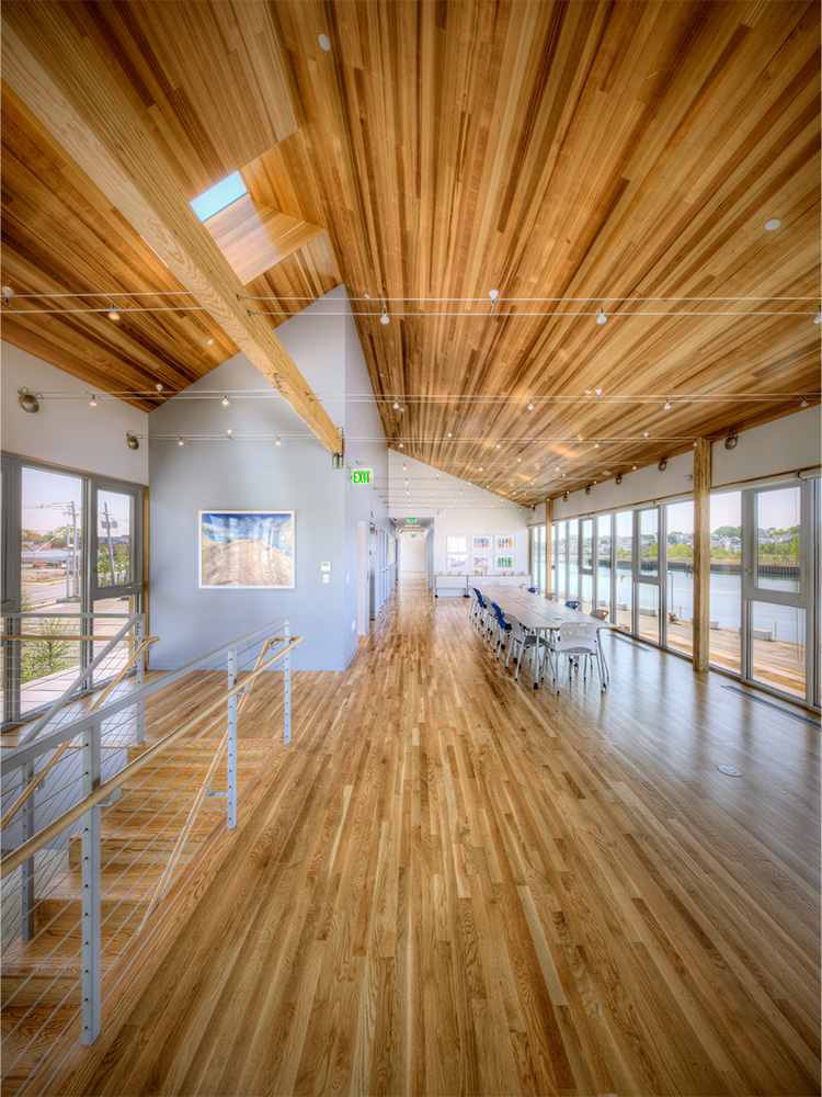 Long lobby room with modern wood panel ceiling, identical to wooden flooring
