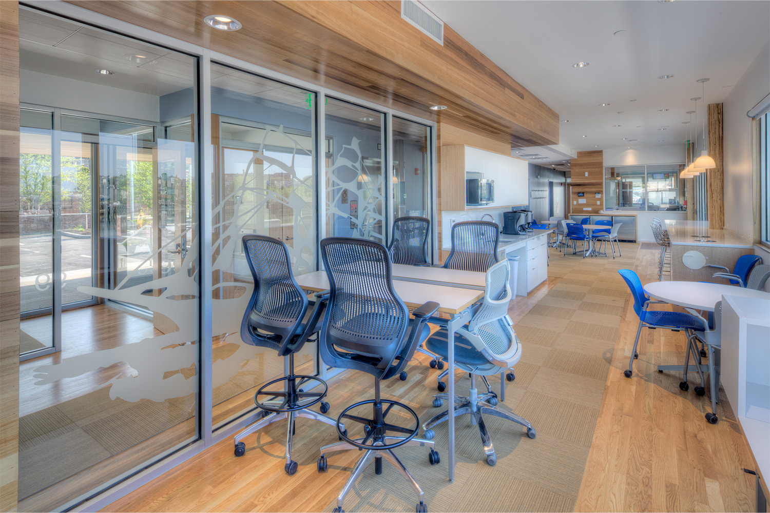 Tables and rolling chairs to utilize work space, along with multiple windows to allow ample lighting