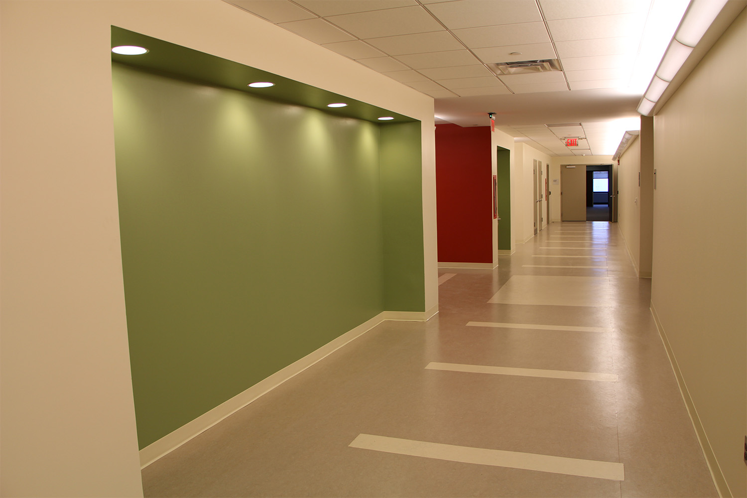 Long hallway with green wall