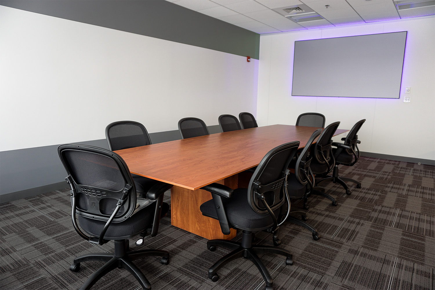 Large conference room with multiple chairs and long tables