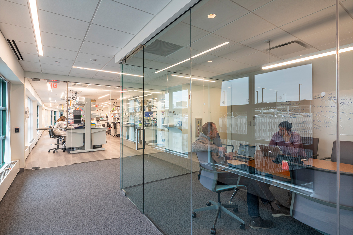 Hallway next to small conference room with glass walls 