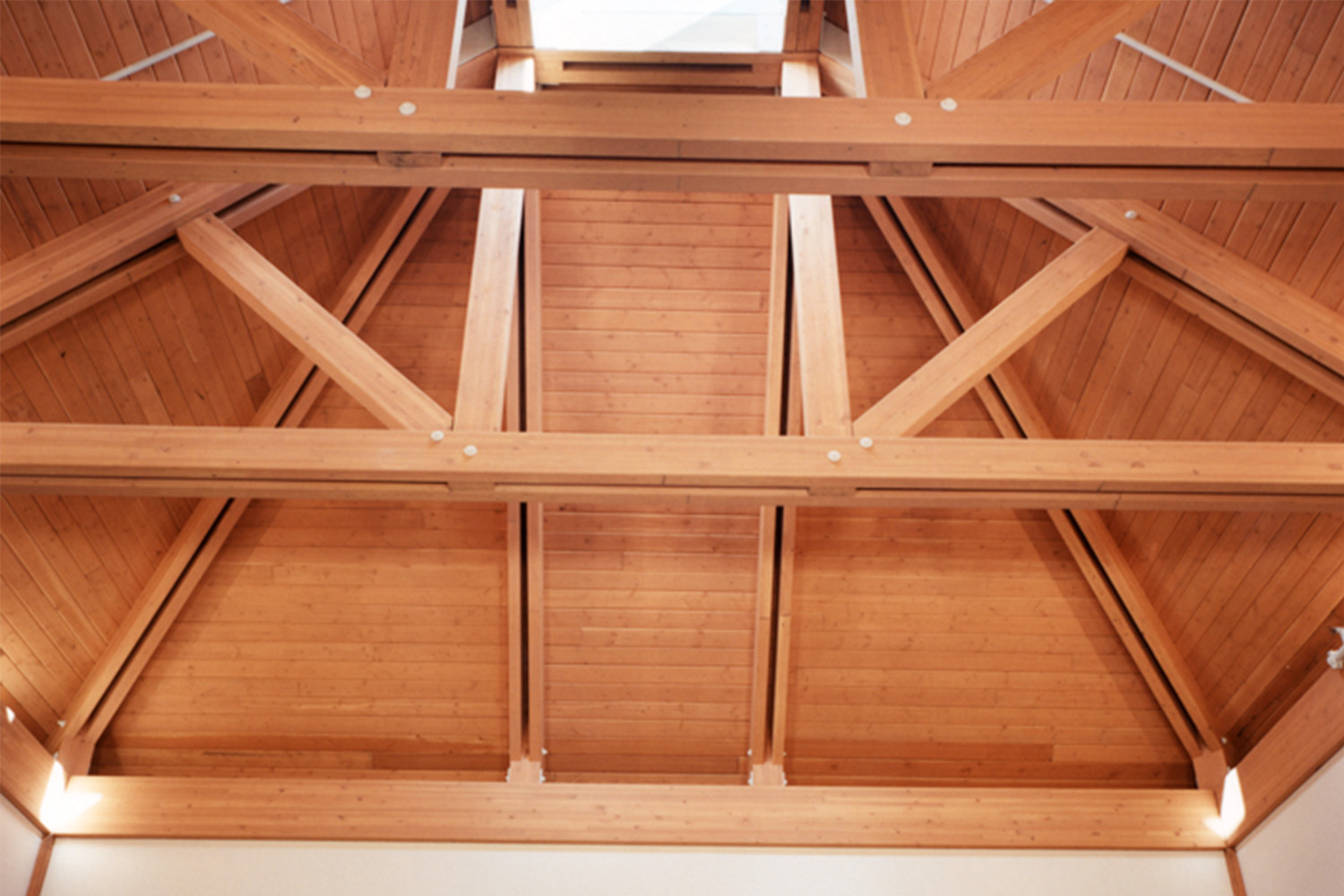 Zoomed-in photo of auditorium ceiling, composed of exposed wooden beams 