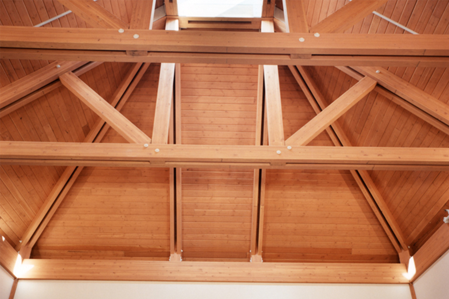 Zoomed-in photo of auditorium ceiling, composed of exposed wooden beams