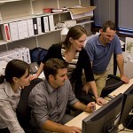 4 people working behind computer