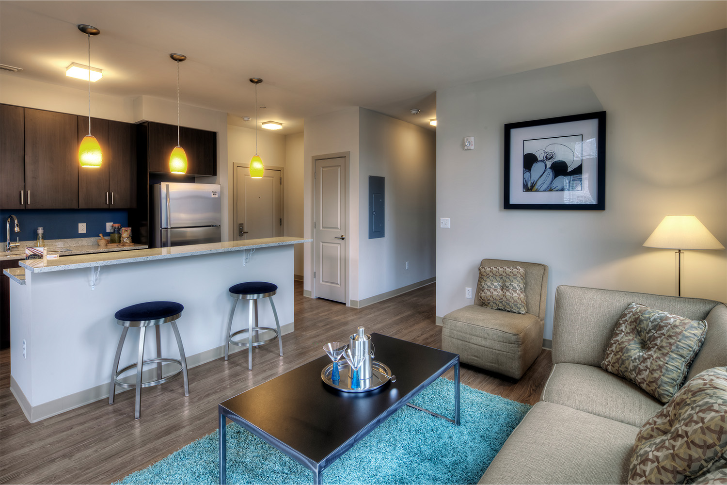 Living room with tan couch and plush blue carpet 