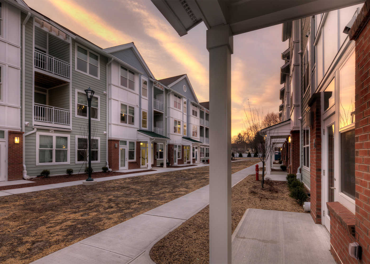 sidewalk in front of façade of apartments