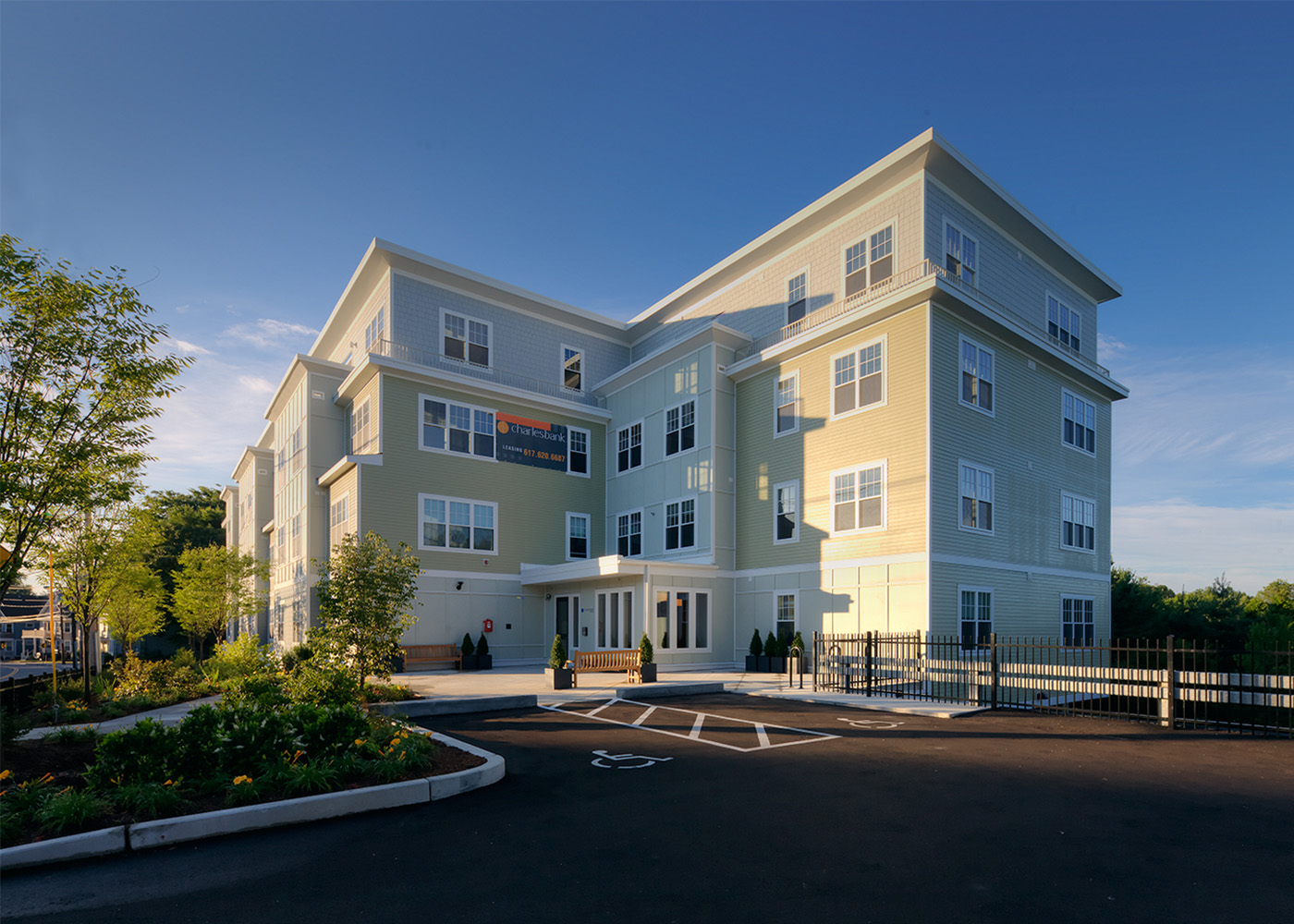 Front exterior of 120 Pleasant Street in front of parking lot, seen at an angle