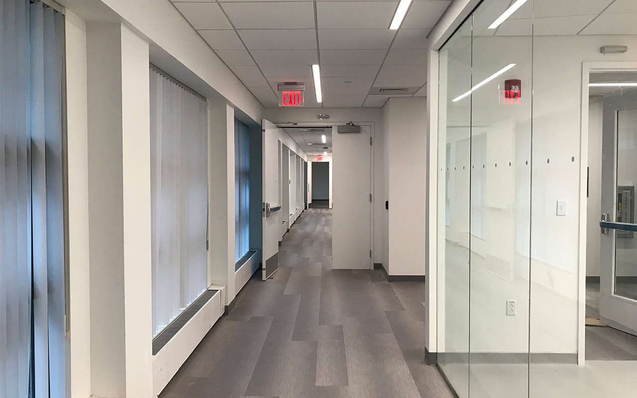 Long hallway with EXIT signs on ceiling 