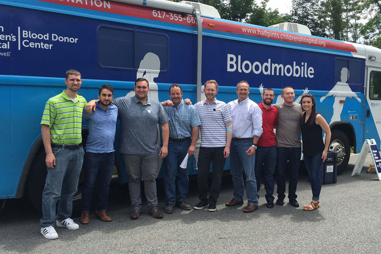 Tocci employees posing for photo in front of blood drive bus 