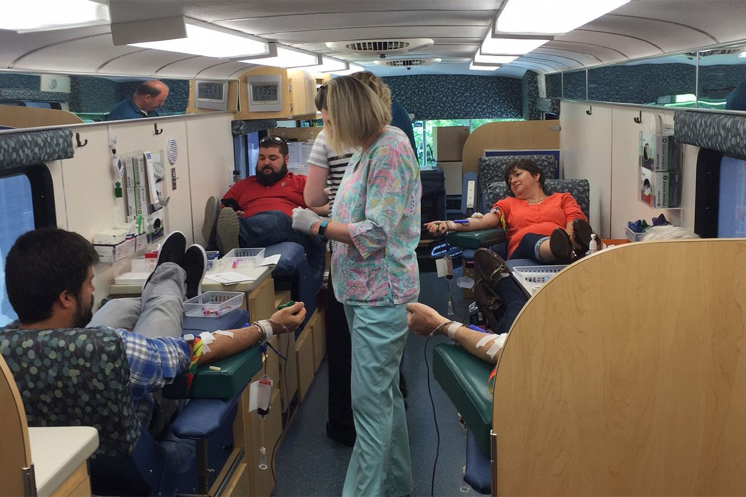 4 blood drive participants lounging as they have their blood drawn 