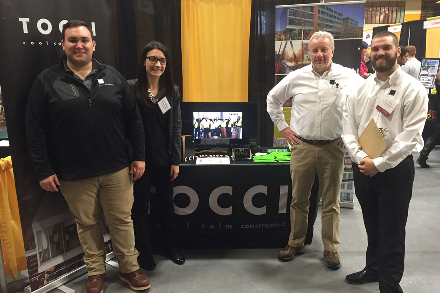 4 people posing by Tocci's career fair table