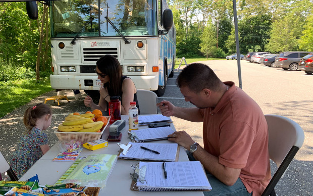 man writing by desk at blood drive 