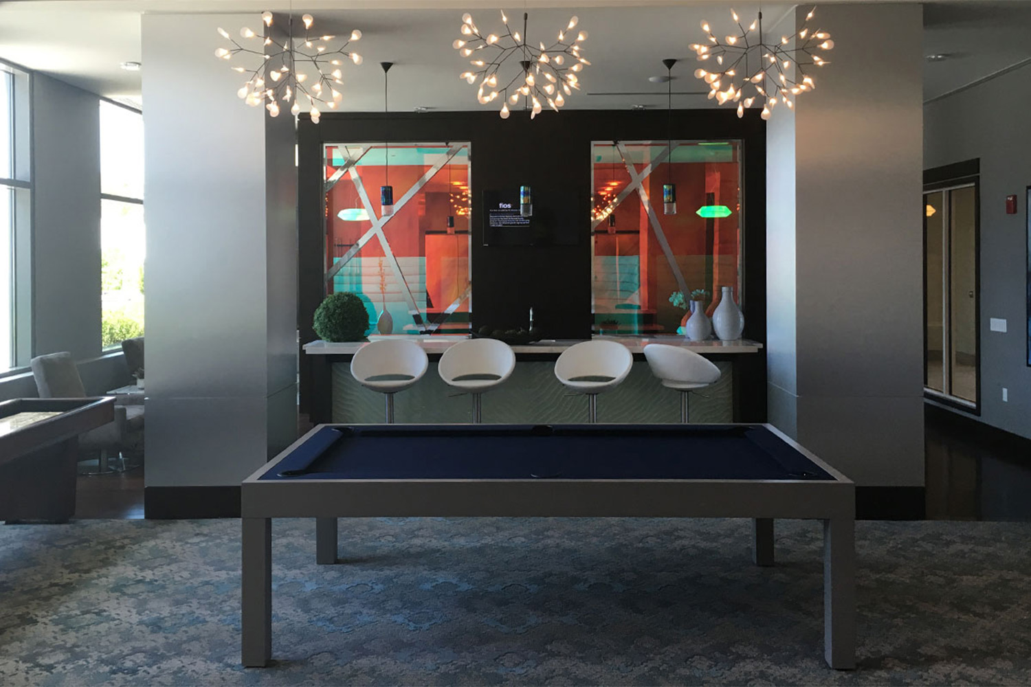Recreation room, with pool table, artful lighting fixtures, and bar area