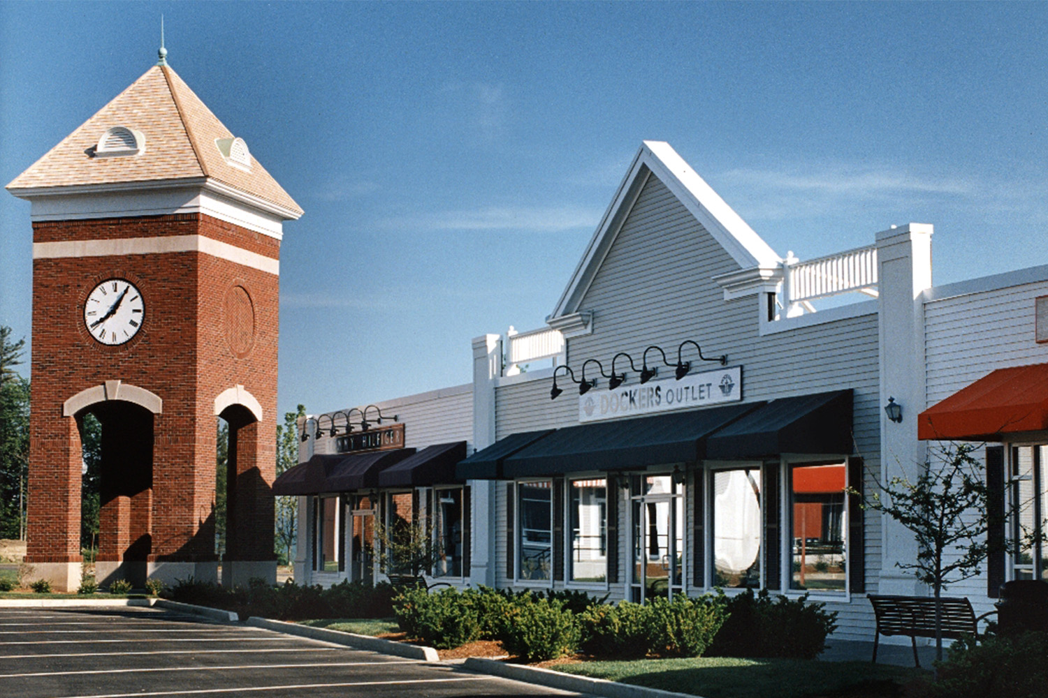 Exterior of "Dockers Outlet" store, next to tall redbrick clock tower