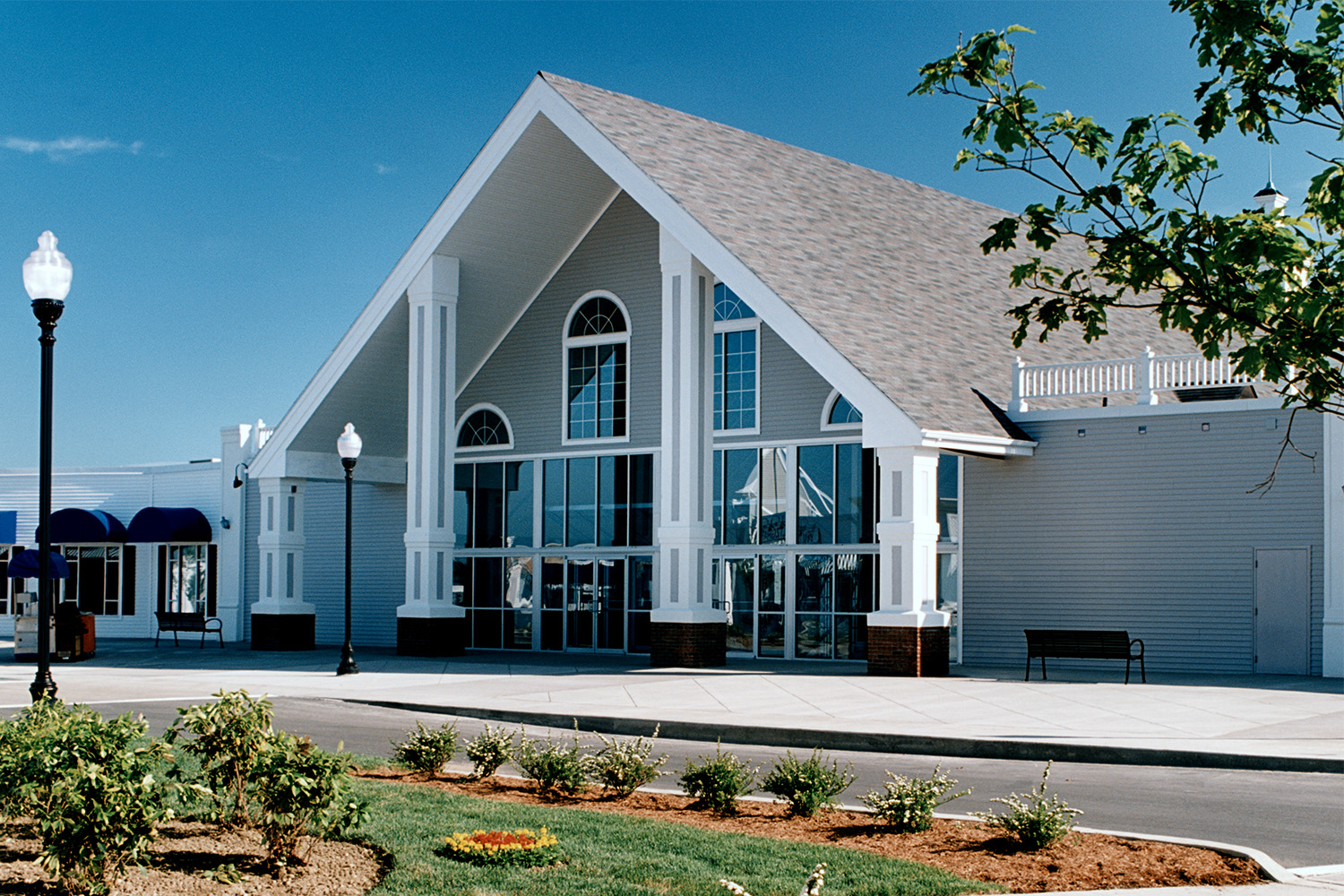 Main entrance to the shopping outlet, with white pillars connecting ground to roof