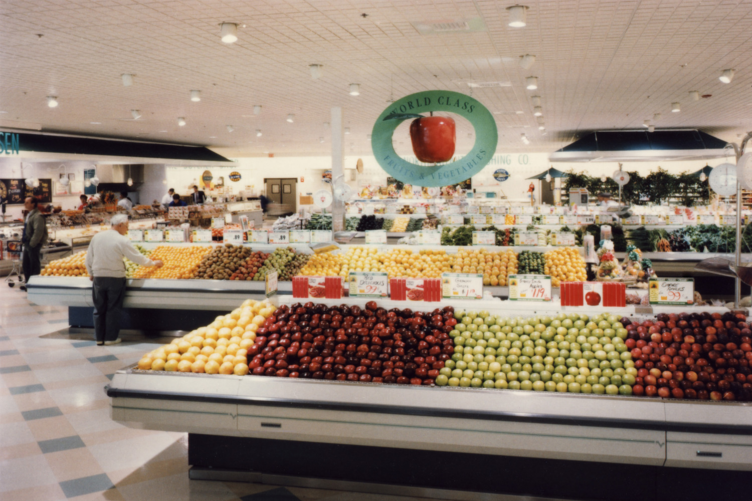 Produce section of grocery store, with assortment of apples to the front 