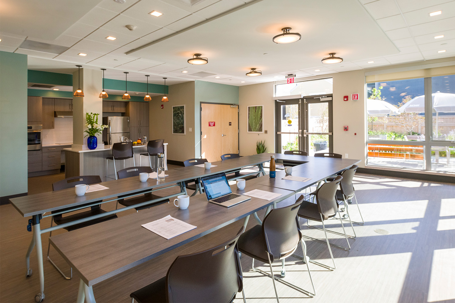 Café & Conference room with ample seating and lighting, with a partial kitchen