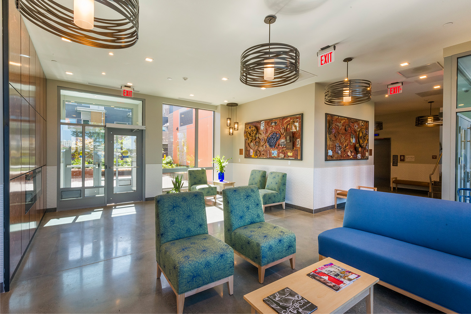 Lobby with elegant light fixtures, and blue couch and chairs
