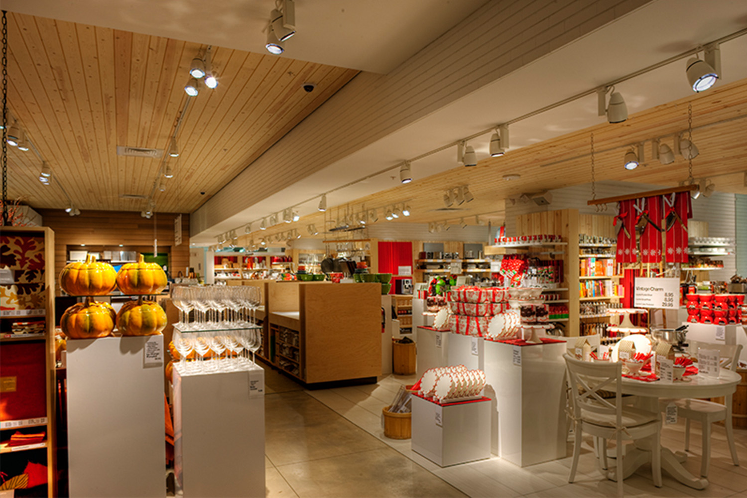 Store merchandise consisting of ceramic pumpkin containers, flower-shaped plates, fondue sets, and various other kitchen materials