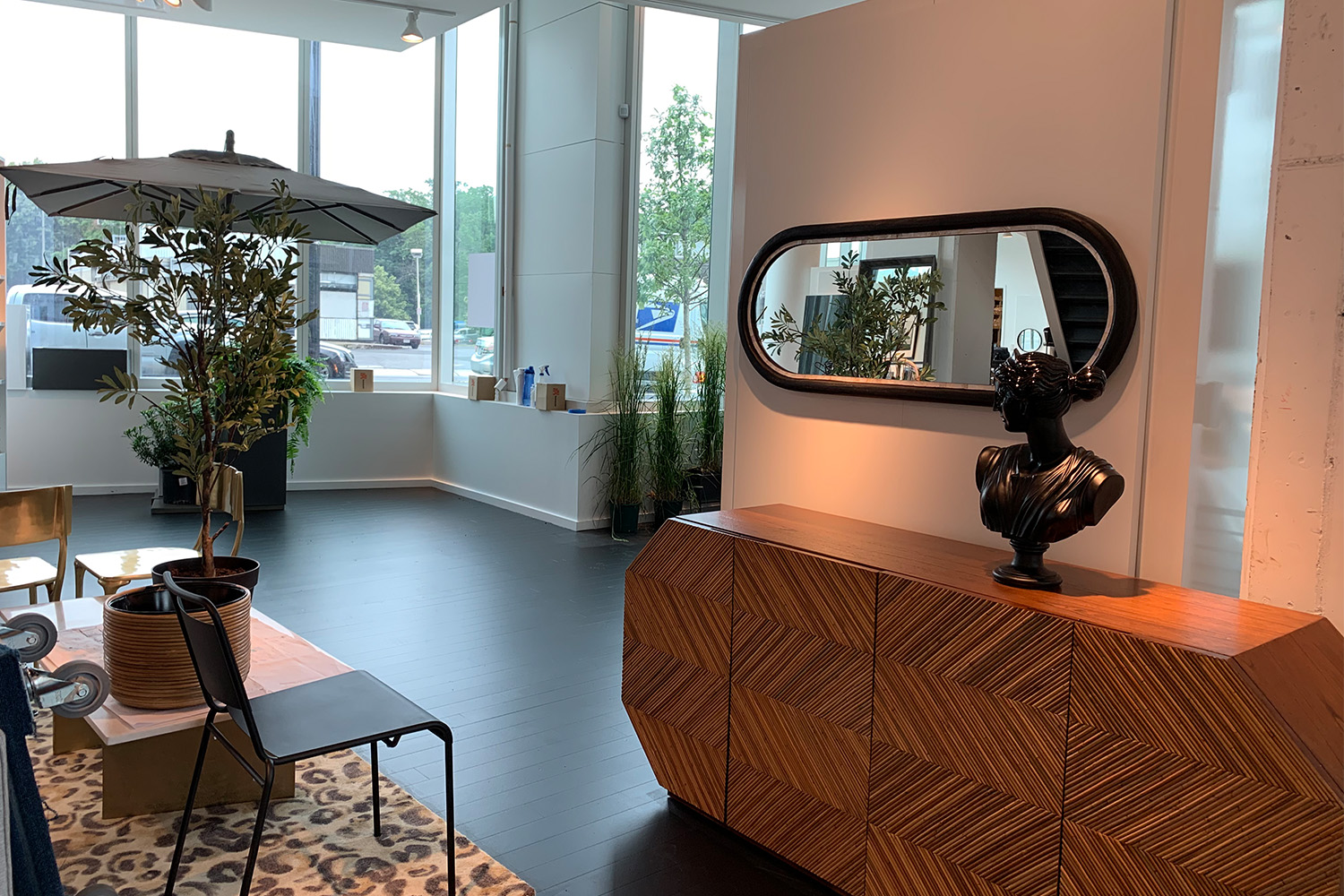 White room with 5 windows, stylish table, and oval shaped mirror 