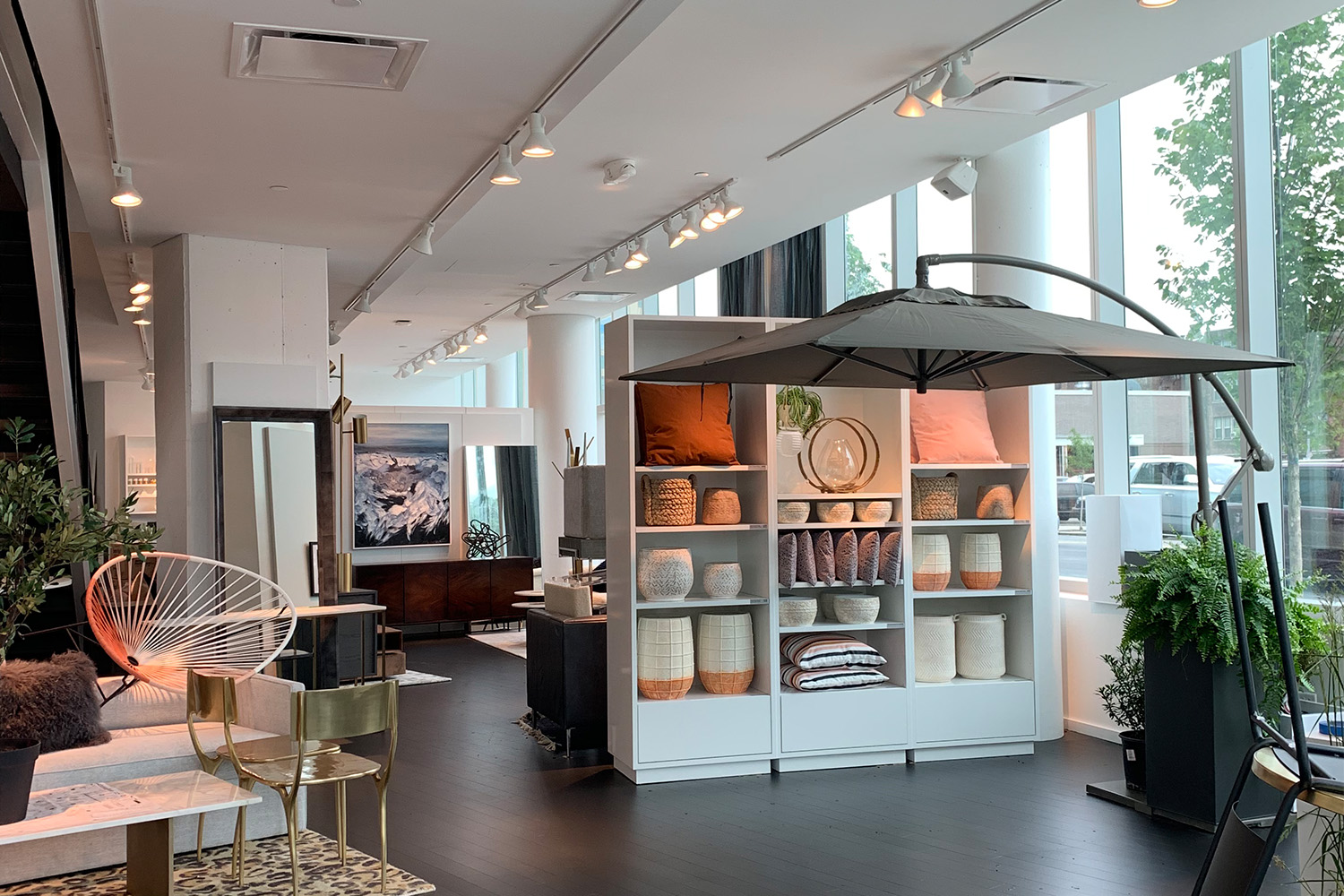 Store room with white clay vases on shelves, planters, and tall windows