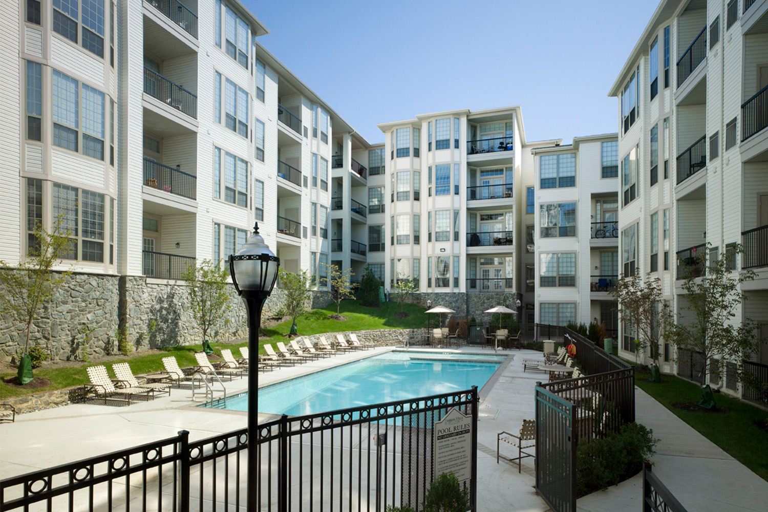 View of large outdoor pool nestled in the center of Dobson Mills at daytime 