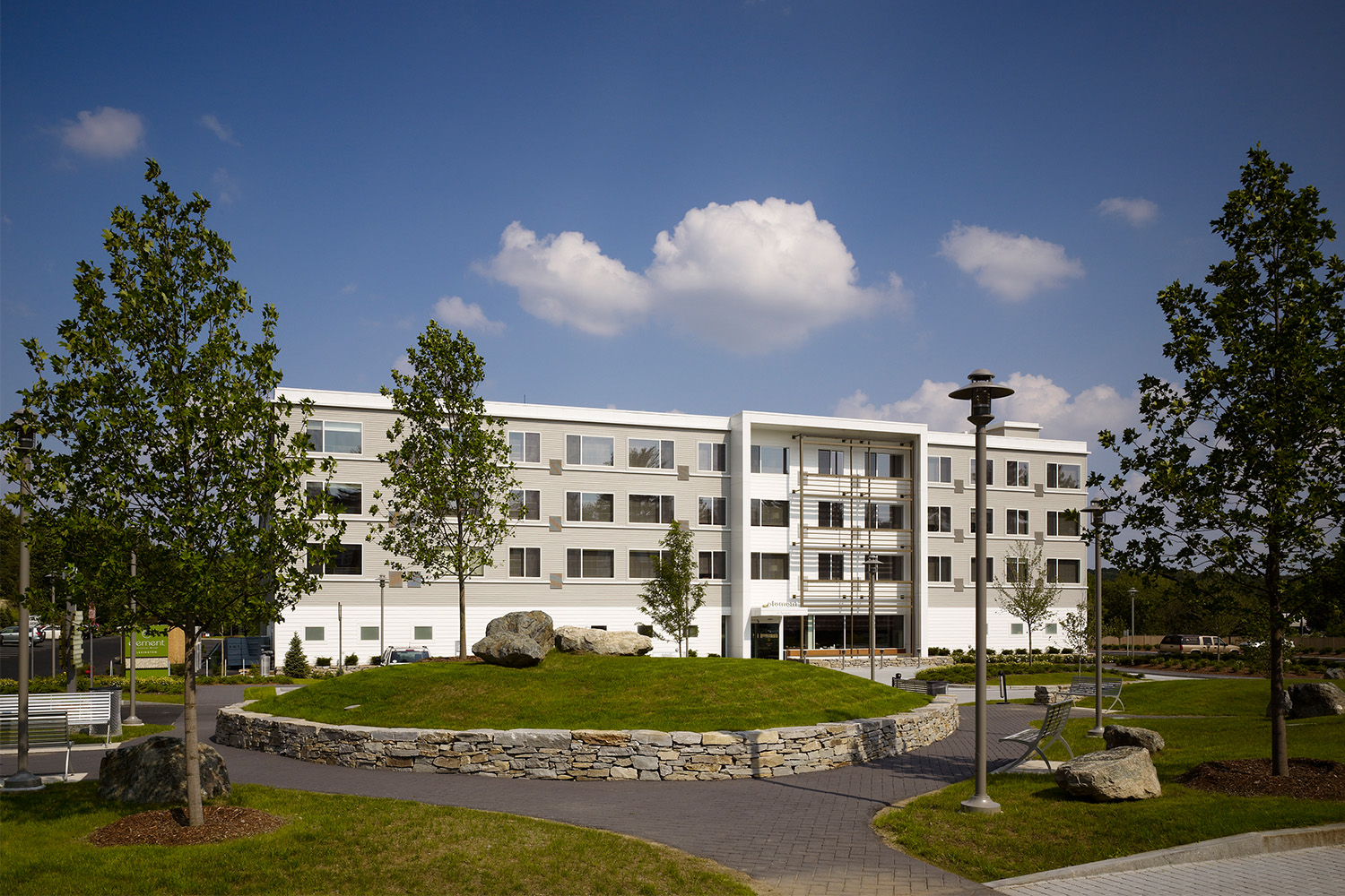 Element hotel with light posts, trees, and walkway in front