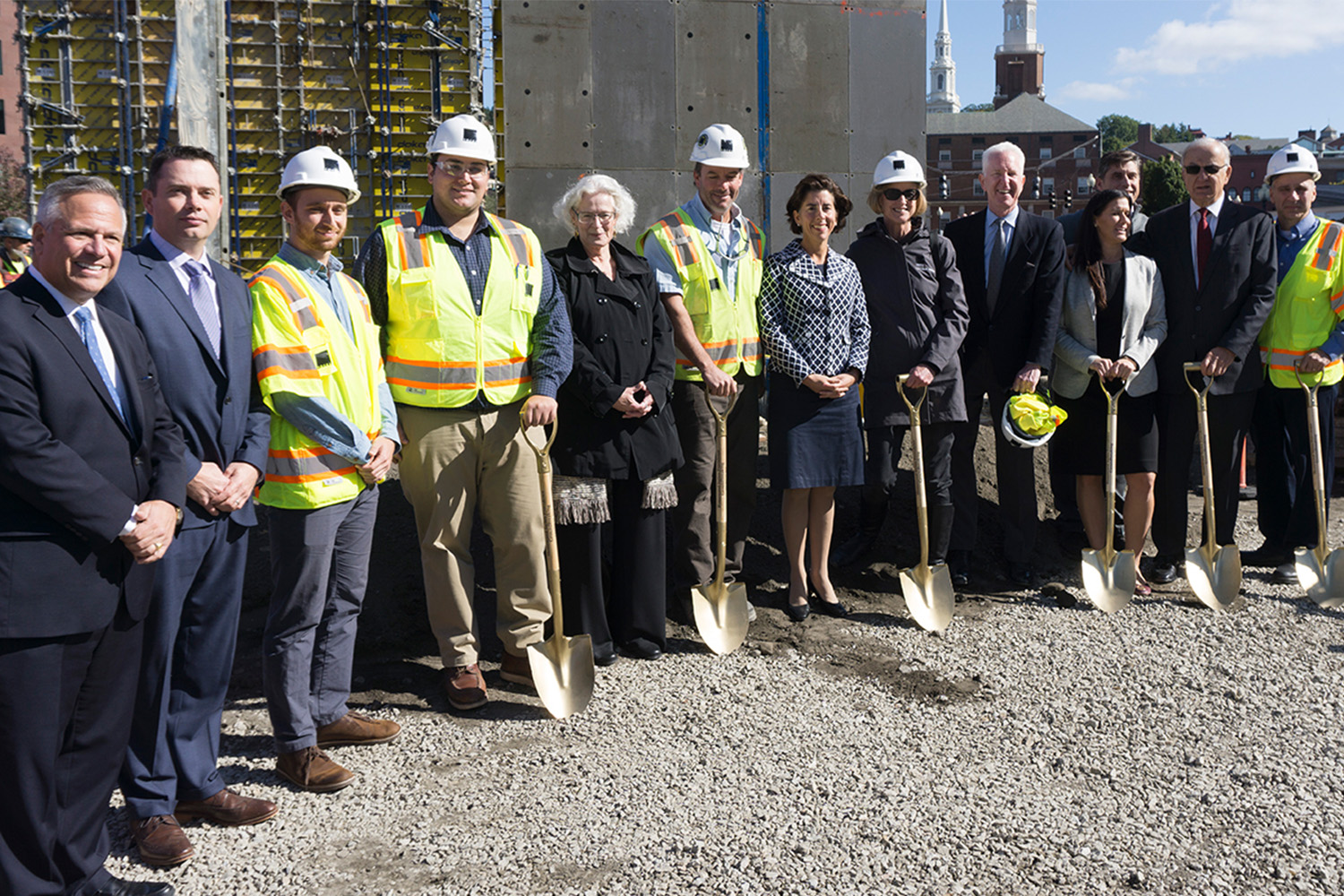 Corporate and construction workers alike, standing in front of newly built hotel
