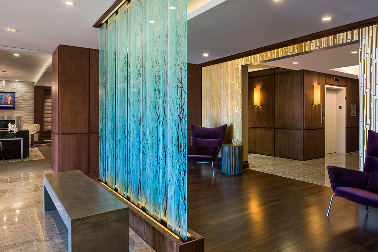 An elegant glass room divider sits between lounge and reception area